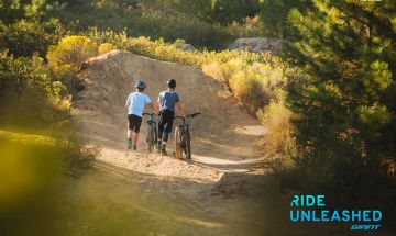 Two bikers near dirt jumps