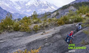 Mountain bikers riding against snowy mountain