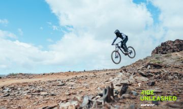 Downhill rider in the air on trail